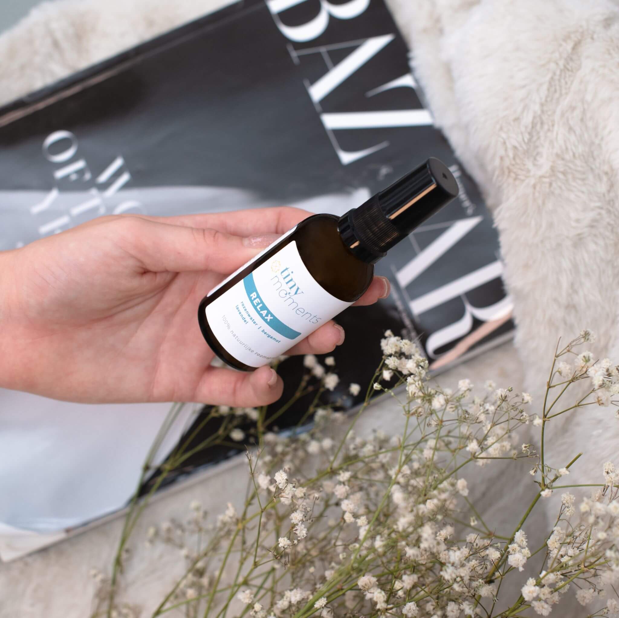 Tiny Moments Roomspray Relax in hand met tijdschrift